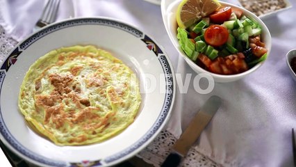 Thick fluffy omelette with green fruits salad hotel food