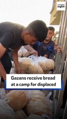Gazans receive bread at a camp for displaced