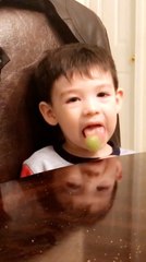 Kid Has Fun Time Licking Lollipop While Sitting at Table