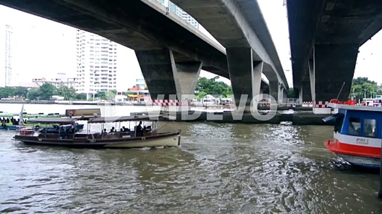 Thai river boat passing under bridge in the centre of Bangkok