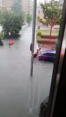 Varias personas mueven un coche en plena tormenta en Valladolid