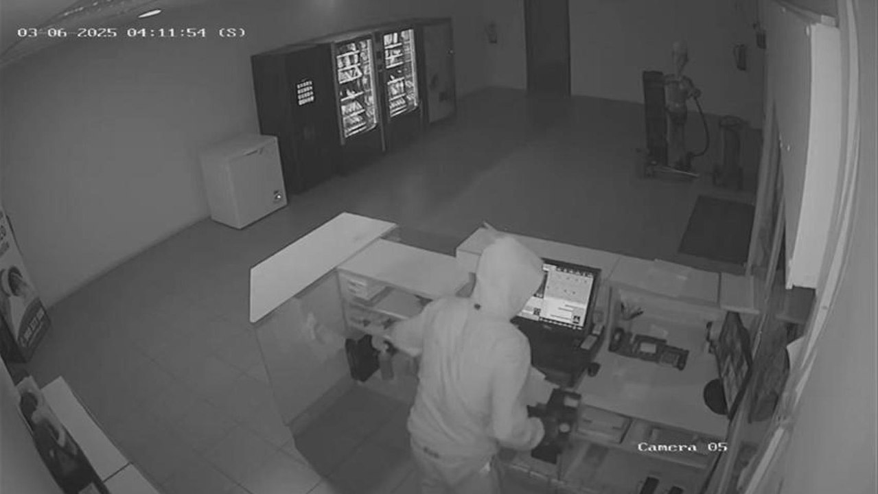 Uno de los encapuchados robando la caja registradora.