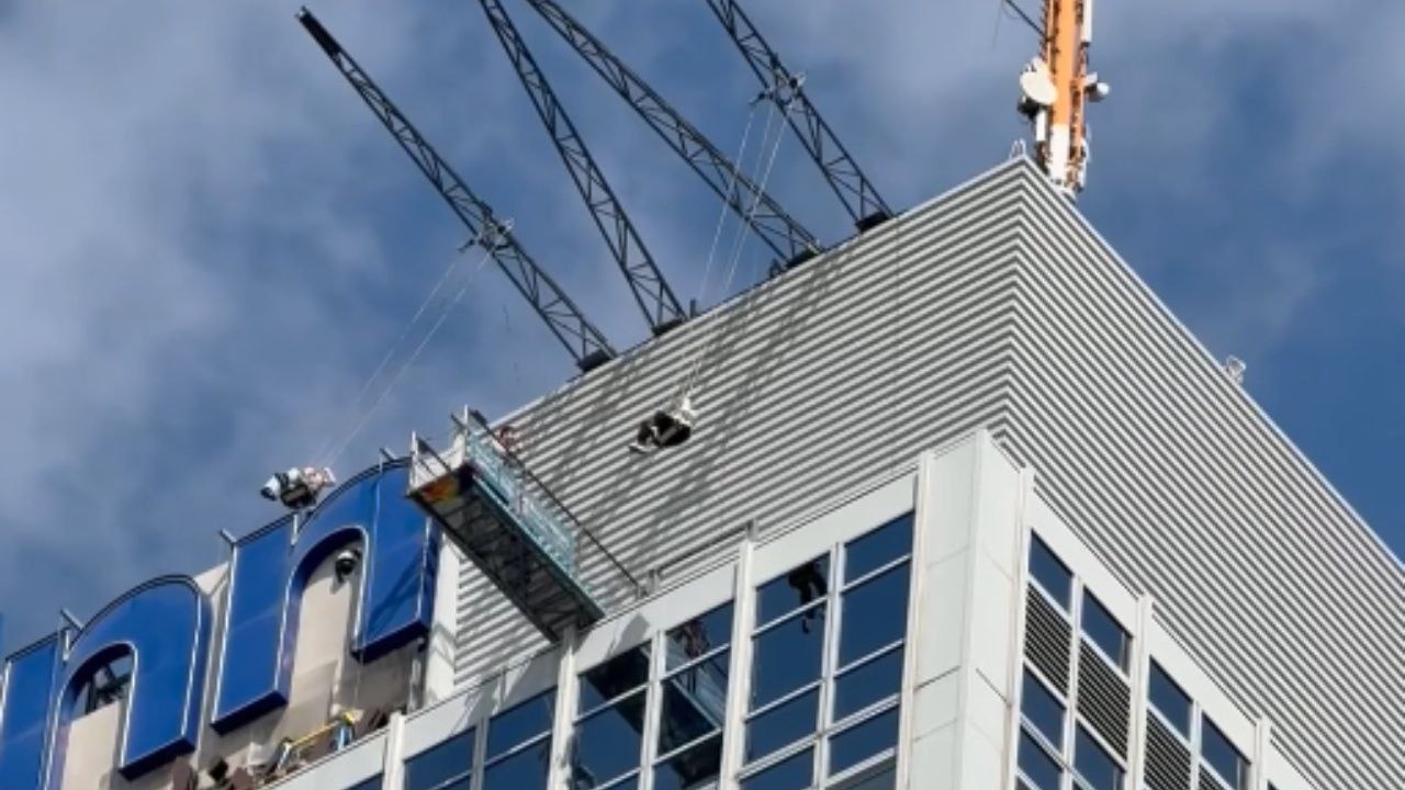 Daredevils swing from tower cranes atop the tallest hotel in Germany