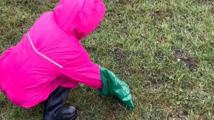 Little girl tries not to throw up while picking up her dog’s poo