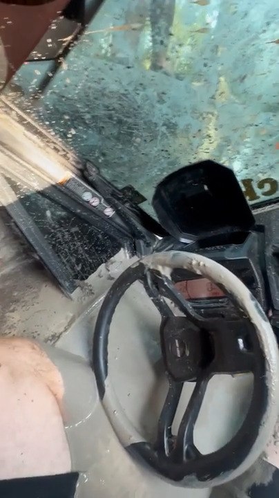 Person Gets Stuck in Vehicle Partially Submerged in Muddy Floodwater