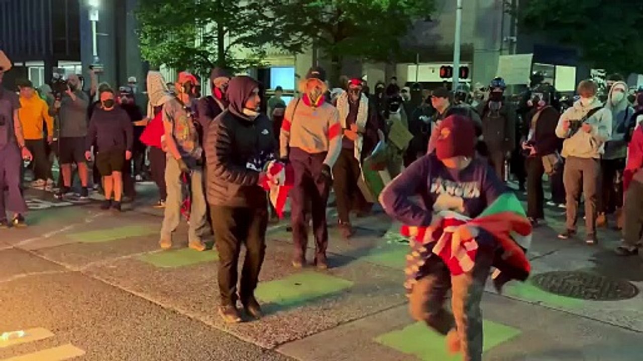 Protestors assault a man that was trying to protect the American flag from being burned