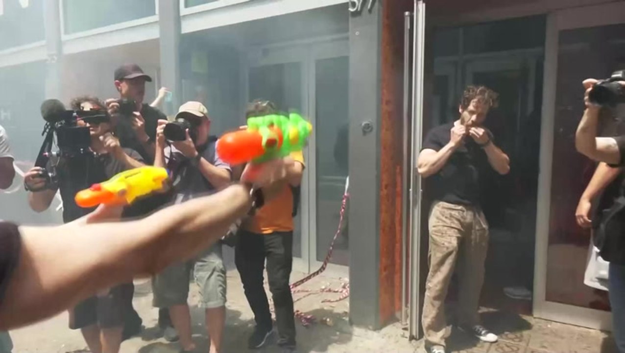 Anti-tourism protesters confront hotel staff with flares and water pistols in Barcelona