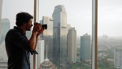 Long Shot of Man Taking Photos of Jakarta