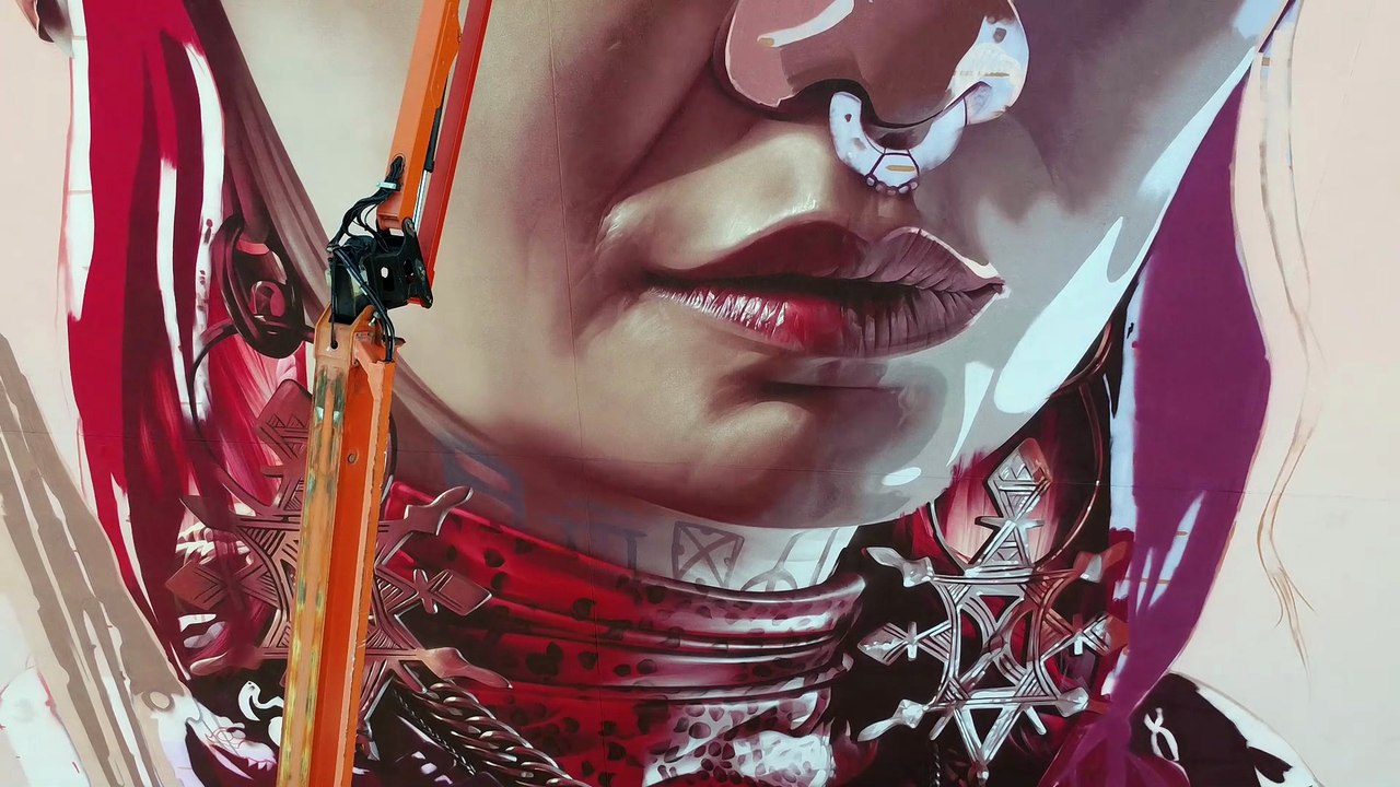 Street artist Smug works on his latest mural, Make Time For What Matters, on the side of The Social Hub Glasgow