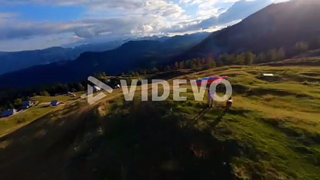 Fpv footage was filmed in the Slovenian mountain village in the alps with a drone flying fast over mountains filmed with a GoPro with incredible surrounding landscapes with a hiker holding a flag