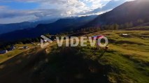 Fpv footage was filmed in the Slovenian mountain village in the alps with a drone flying fast over mountains filmed with a GoPro with incredible surrounding landscapes with a hiker holding a flag