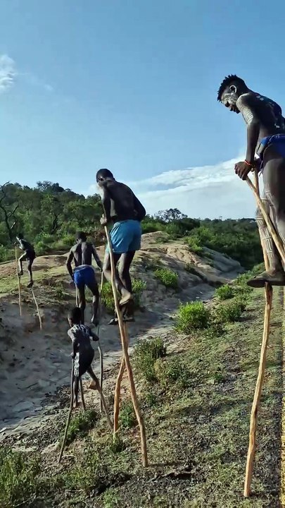 Walking on stilts Omo Valley Banna Tribe boys.