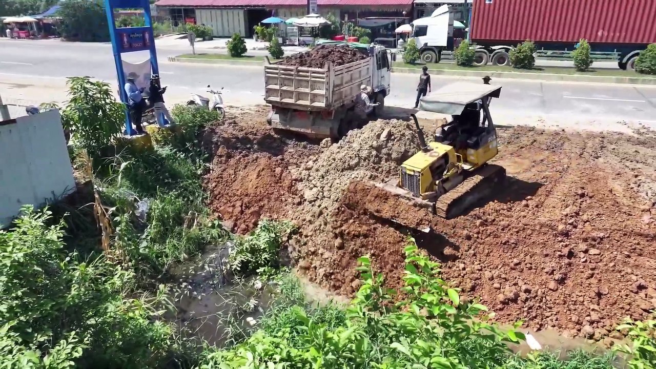 Perfectly compacted waste using a Komatsu D20A bulldozer earth mover, and garbage truck.