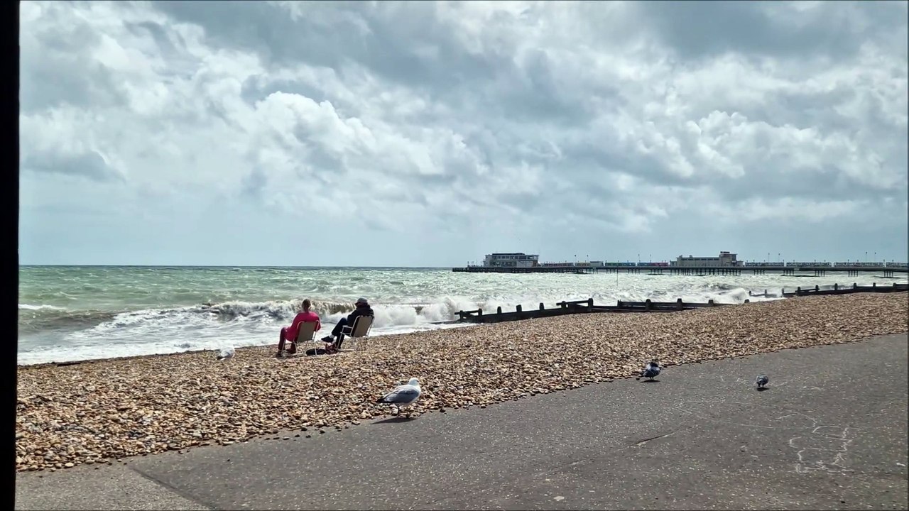 Watch one couple's response to the wind blowing a hoolie and the waves smashing on the shore on Worthing beach