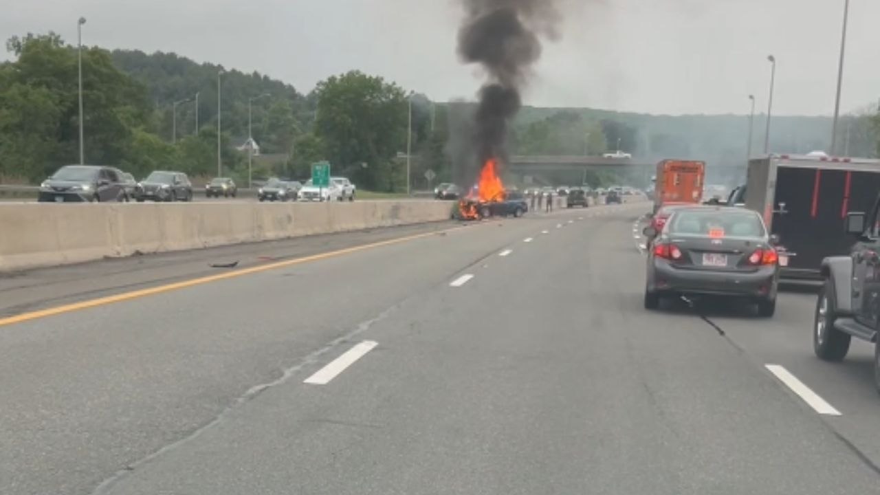 Woman captures startling footage of a car on fire on I-90 while traffic continues around it
