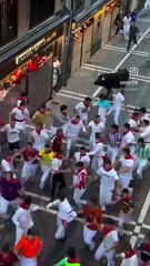 Encierro de San Fermín con una cogida y un hombre grabando en la cara del toro