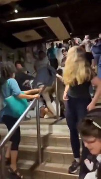 In UK, a black man hits a white man who's holding a baby, who falls to ground. Then the British people present explain to him that UK is no joke. Education is important.