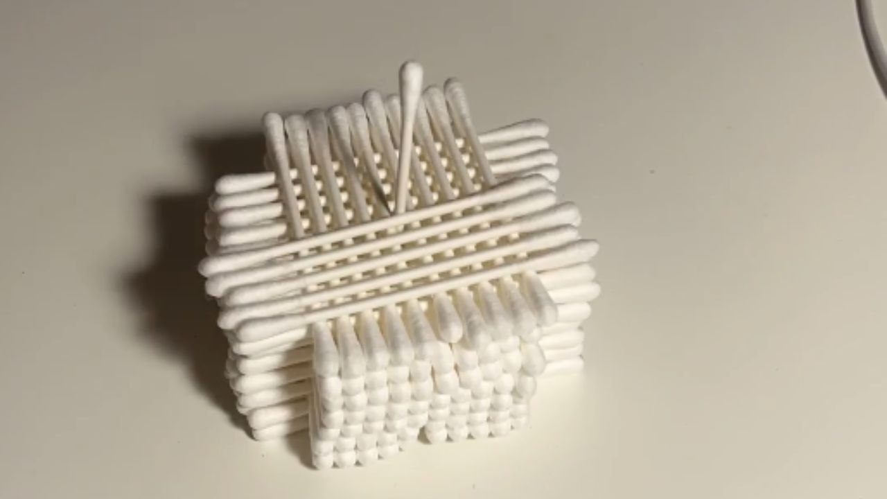 Boy creates a 3^3 cotton swab cube with steady hands