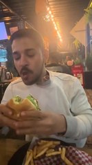 Dog Adorably Peeks From Inside Man's Coat to Grab Some Food