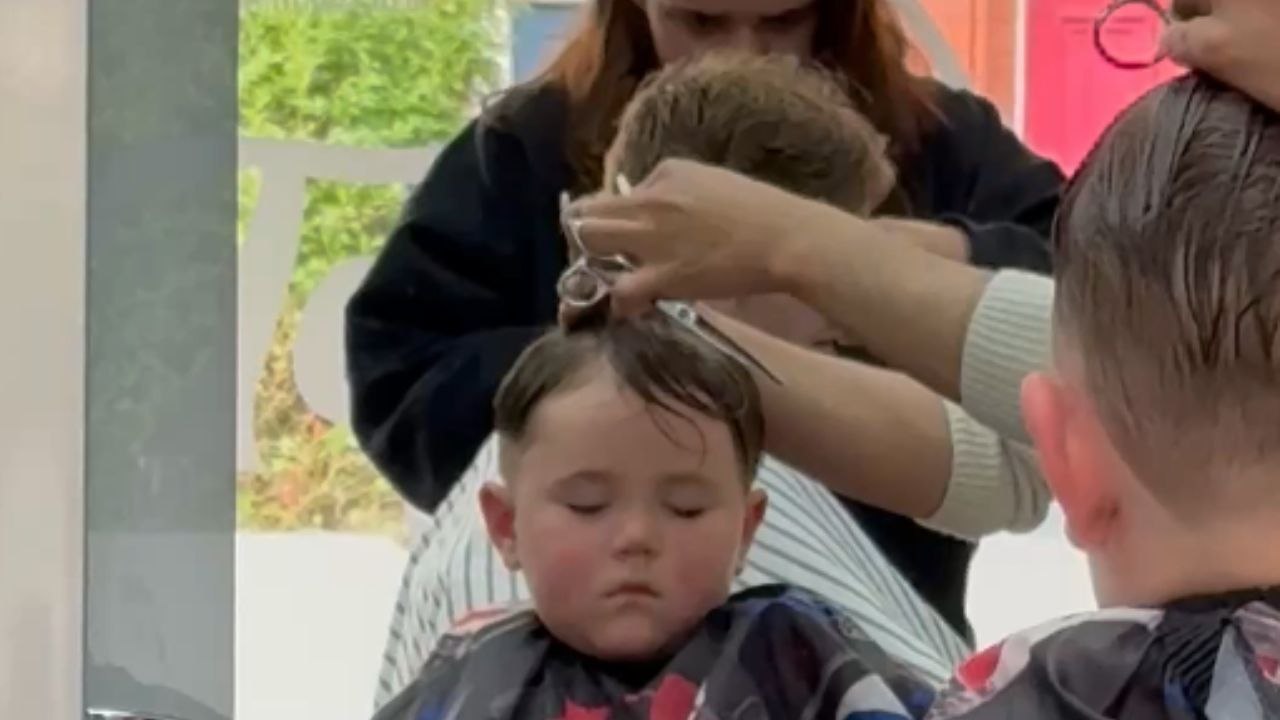 Little boy takes a nap while getting a haircut and stays unbothered