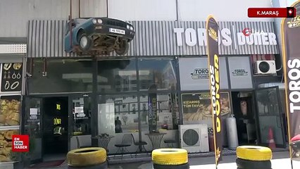 Kahramanmaraş’ta depremde yarısı enkazda kalan otomobili dükkanına astı