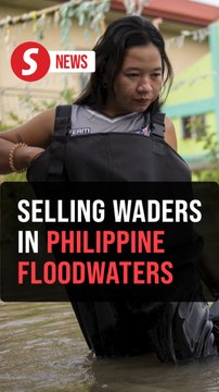 Selling waders in waist-high Philippine floodwaters