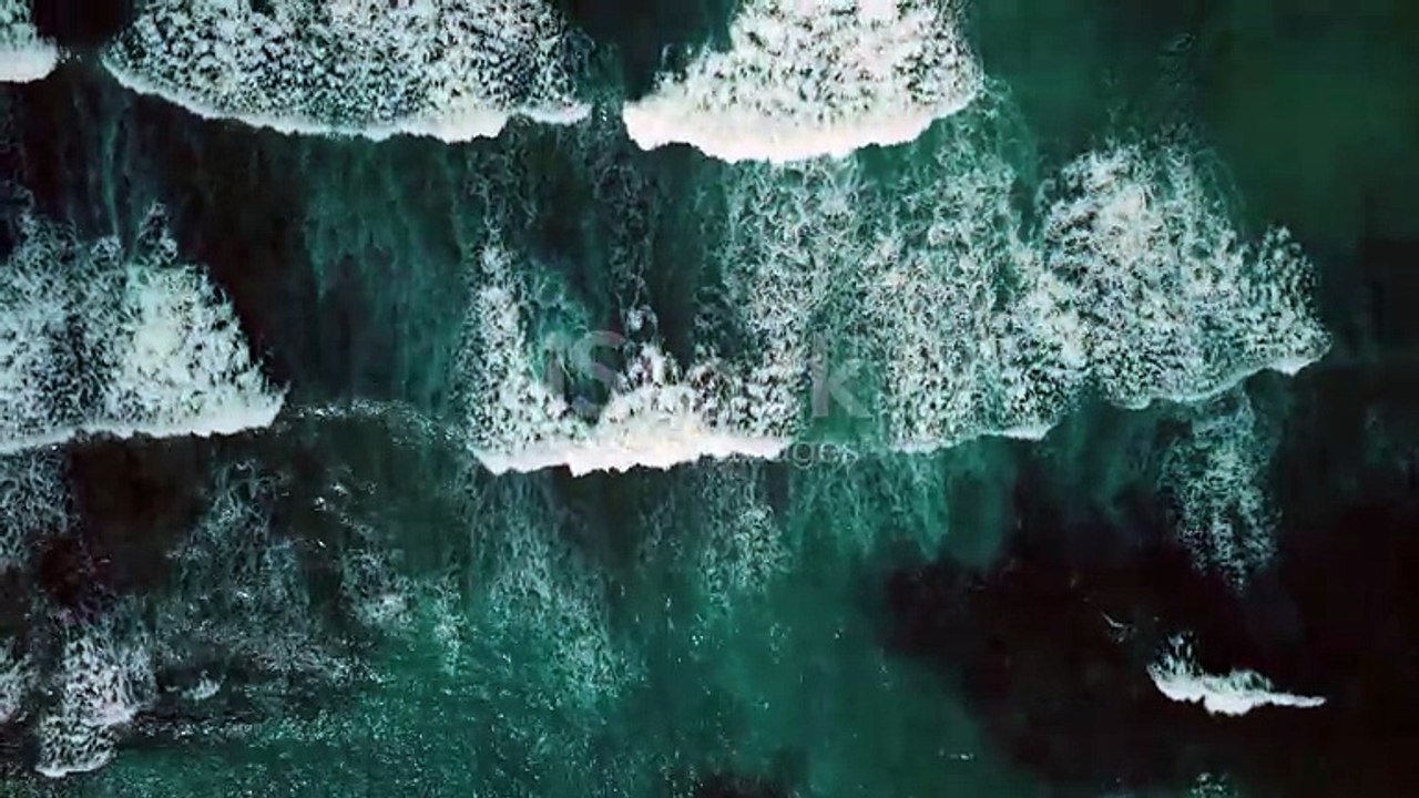 Beautiful texture of big power dark ocean waves with white wash. Aerial top view footage of fabulous sea tide on a stormy day. Drone filming breaking surf with foam in Caribbean Sea
