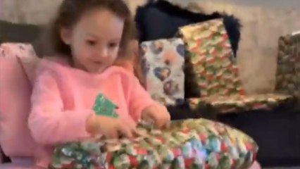 Little girl receives a christmas gift with her dog's face on it