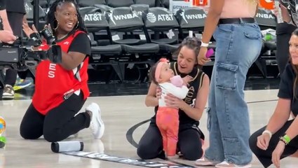 Baby takes first steps during crawling race at WNBA half time show