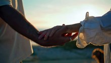 couple holding hands at sunset on the beach