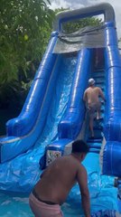 Two Men Collide While Having Fun on Inflatable Water Slide