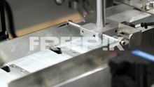 machine attaching ear loops to surgical mask pleated fabrics on conveyor