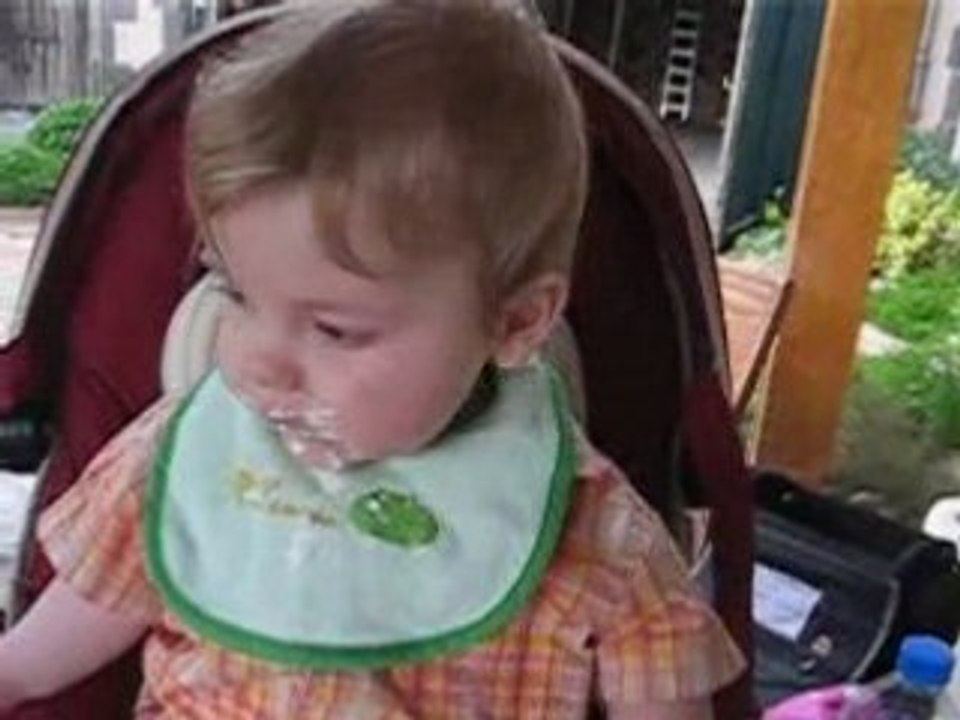 Simon mange sur la table du jardin