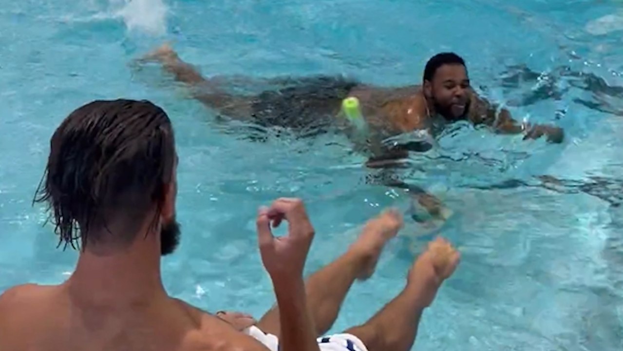 Michael Phelps teaching Travis Jones how to swim with the help of a pool noodle