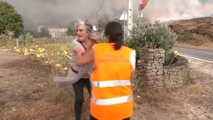 Una mujer desgarrada mientras es obligada a abandonar su casa por los incendios