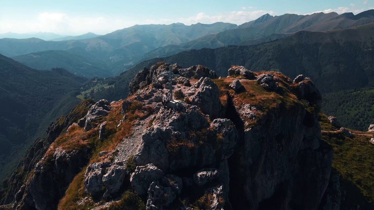 Drone Video of a Man Sitting by the Cross on the Top of Monte Grona, Italy