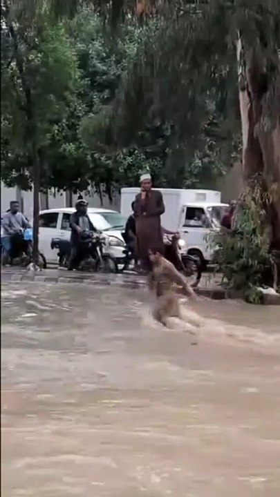 ، واہ کیا بے فکری عمر ھے۔سیلابی پانی میں بچے کا کھیلنا