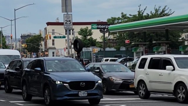 Daredevil balances a tire on his head while cycling through traffic in Brooklyn