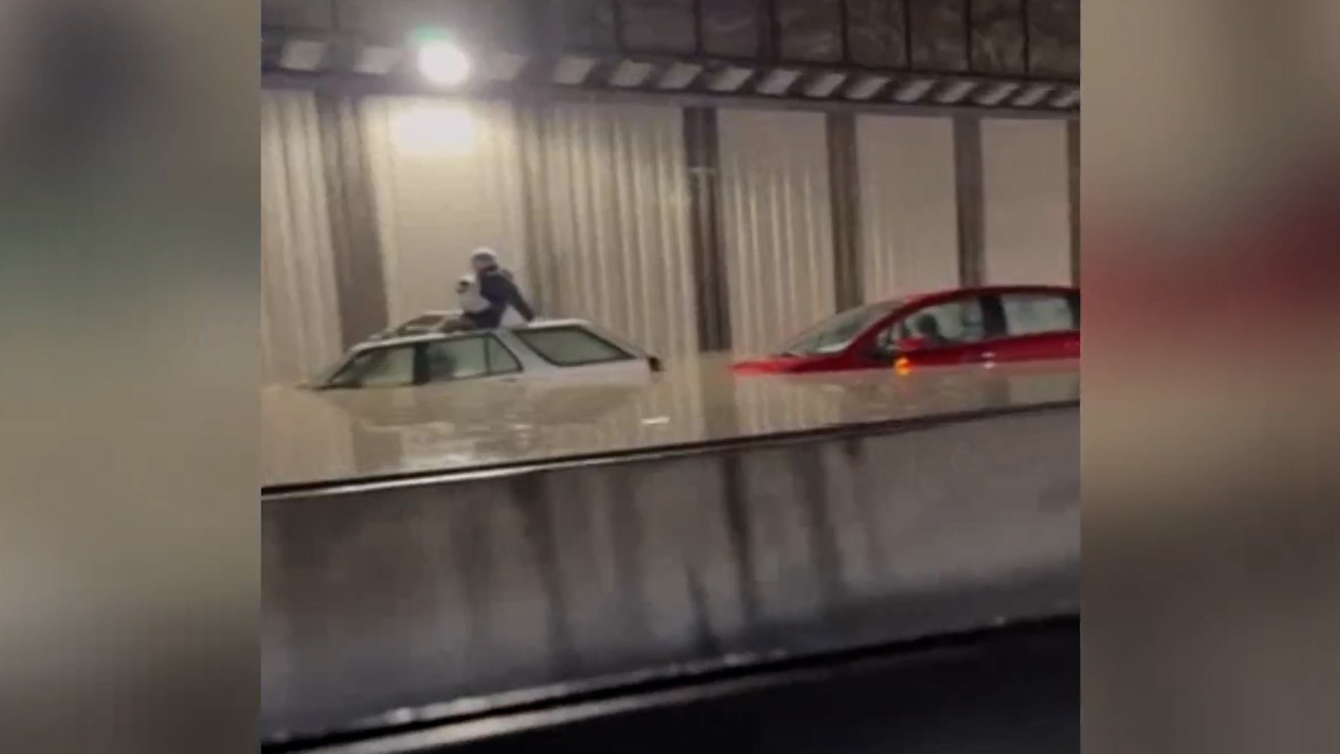 Madrid ha vivido una ma�ana de jueves marcada por el colapso en sus comunicaciones con el aeropuerto. Una aver�a de gran magnitud en la red de suministro de agua ha provocado inundaciones cr�ticas en las principales arterias que conectan la capital con el Aeropuerto Adolfo Su�rez Madrid-Barajas, dejando atrapados a numerosos conductores y obligando a suspender servicios de transporte p�blico esenciales. Los Bomberos del Ayuntamiento de Madrid trabajan desde antes de las 10.00 de este jueves para desaguar el t�nel de la T-4, en Barajas, que qued� inundado con una decena de veh�culos en su interior por la rotura de una arteria del Canal de Isabel II en la avenida de Logro�o.
El incidente se inici� en plena hora punta, lo que gener� escenas de gran tensi�n bajo tierra. Los hechos se produjeron cerca de las 8.00 horas. La inundaci�n del t�nel dej� a una veintena de personas atrapadas en el interior. Los Bomberos del Ayuntamiento rescataron a dos de ellas y el resto pudo salir por su propio pie, sin que nadie resultara herido. La r�pida intervenci�n de los equipos de emergencia evit� da�os personales mayores en un escenario donde el nivel del agua subi� de forma s�bita.
La rotura no solo afect� al tr�fico rodado, sino que ha inutilizado el acceso ferroviario m�s importante al aeropuerto. Tanto el t�nel de acceso a la T4 como la M-14 est�n cortadas por lo ocurrido. Tambi�n hay afectadas varias casas de la avenida de Logro�o y est� cortada parcialmente la circulaci�n de la l�nea 8 de Metro entre la T1-T2-T3 y Aeropuerto T4, ya que el agua tambi�n penetr� hasta las instalaciones de dicha l�nea. Esta situaci�n ha obligado a miles de viajeros a buscar alternativas para no perder sus vuelos.
Como medida excepcional para mitigar el caos circulatorio, con motivo del incidente la Delegaci�n del Gobierno en Madrid anunci� el levantamiento del peaje de la M-12 en ambos sentidos para facilitar la circulaci�n.
La magnitud de la inundaci�n ha sorprendido incluso a los operarios del Canal de Isabel II. Seg�n el jefe de guardia de los bomberos, Roberto Gonz�lez, la inundaci�n elev� el nivel del agua hasta 1,40 metros y una decena de veh�culos quedaron en el interior del t�nel. Las labores de recuperaci�n se prev�n largas debido al gran volumen de agua acumulada.
De hecho, antes de las 10.00 horas comenzaron los trabajos para el desag�e de la infraestructura. Posteriormente se realizar� la retirada de los veh�culos. El incidente llega en una semana de fuertes lluvias en la capital que se prolongar�n durante este jueves. La combinaci�n de la aver�a t�cnica y la inestabilidad meteorol�gica mantiene en alerta a los servicios municipales de Madrid, que recomiendan evitar el uso del veh�culo privado en la zona noreste de la ciudad.