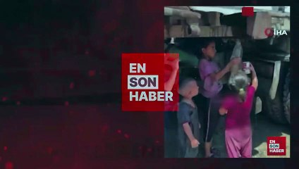Gazzeli çocuklar kamyondan akan kirli suyu ellerindeki kaplara doldurdu