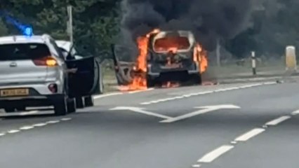 Intense scene on the A55 as car burns while police monitor the scene