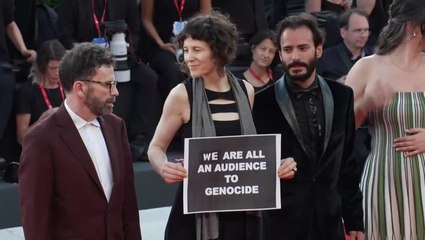 Venice Film Festival writer holds up ‘We are all an audience to genocide’ poster on red carpet