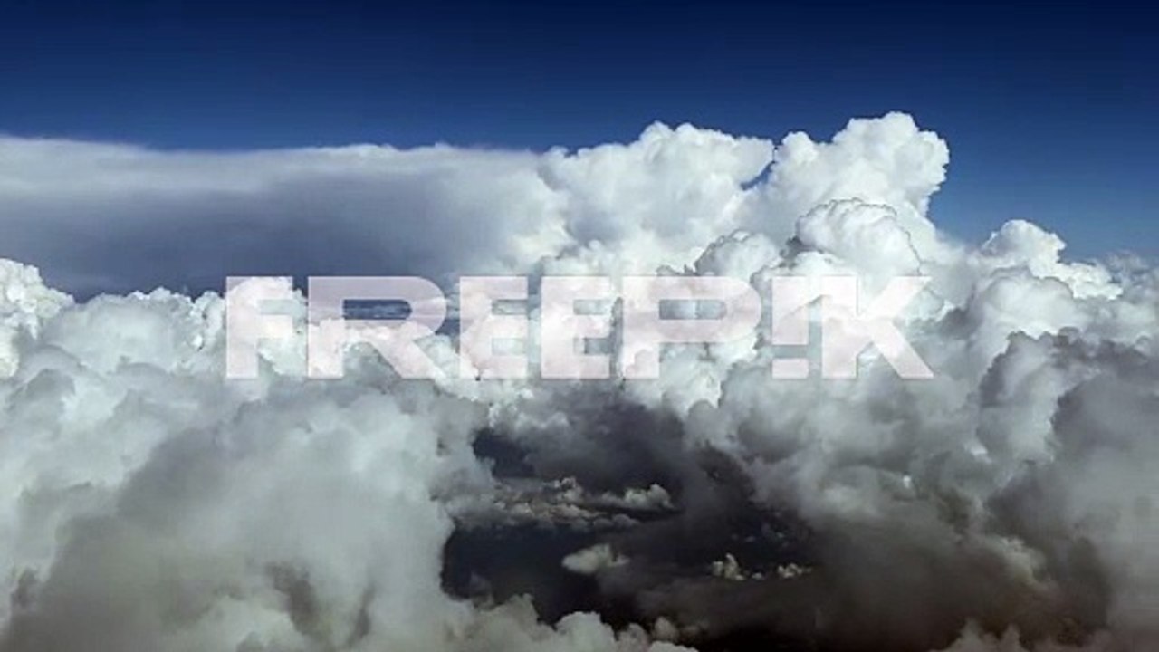 aerial view taken from a cockpit of some huge white cumuloninbus during daylight at cruise level