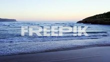 cantabrian sea tide enters secluded playa de la arena sunset glow low aerial