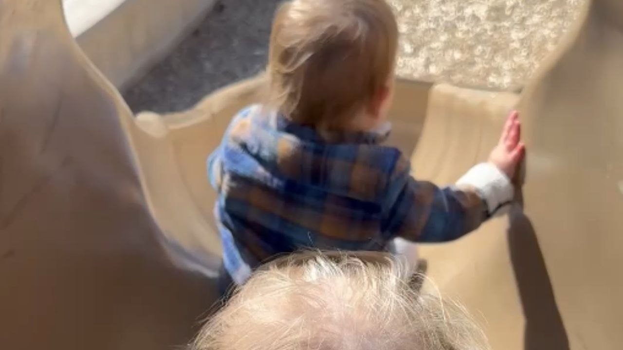 Little boy flips off slide while trying it alon...