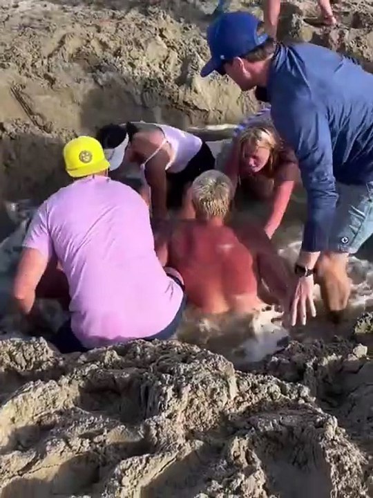 Deux enfants coincés dans un trou qu'ils ont creusé dans le sable
