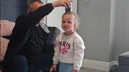 Little girl balances an imaginary can on head with focus and care