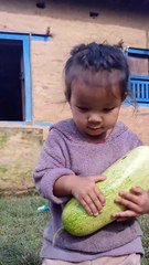 Little cute baby with cucumber