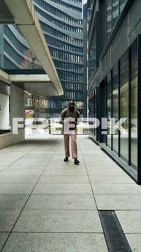 Man Walking in Urban Business District with Coffee