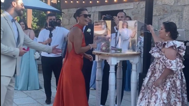 Boy gets down on one knee and proposes to girl at a wedding ceremony